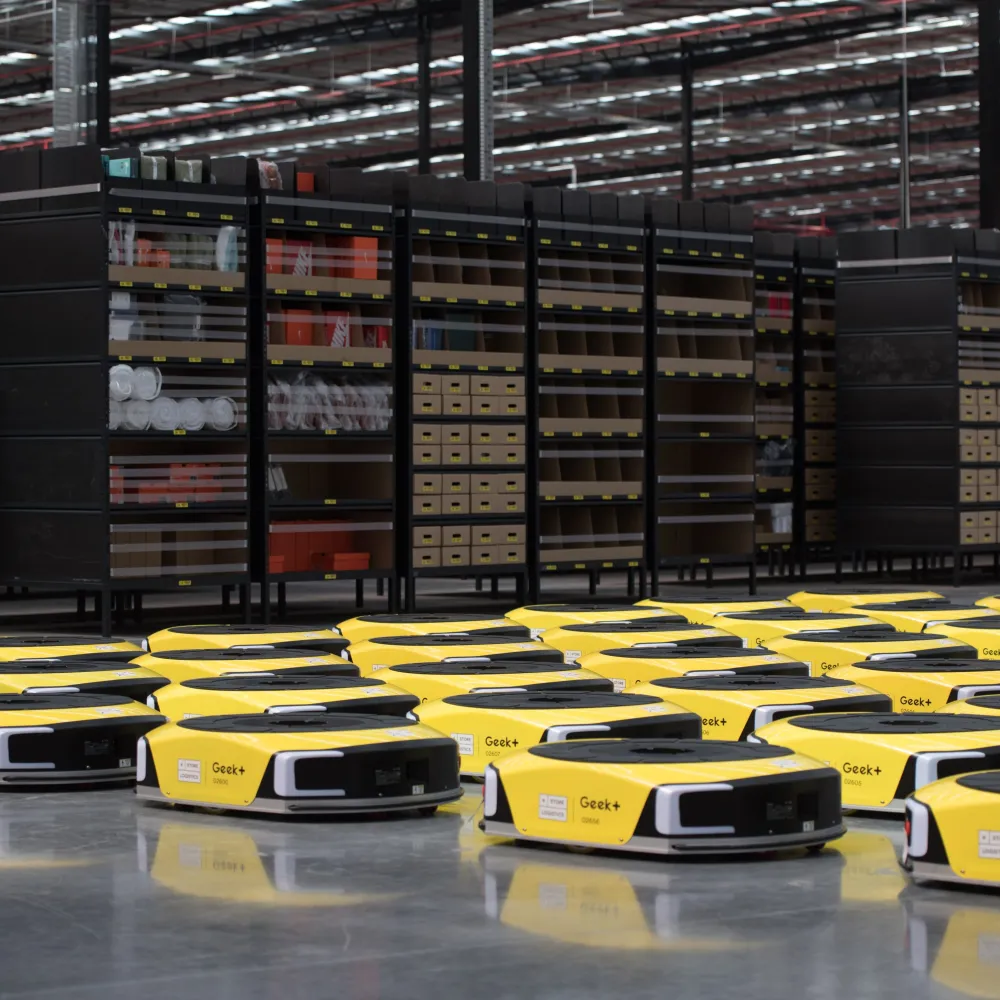 eStore Logistics warehouse with yellow Geek+ automated robots navigating between stocked shelves, optimising order fulfillment