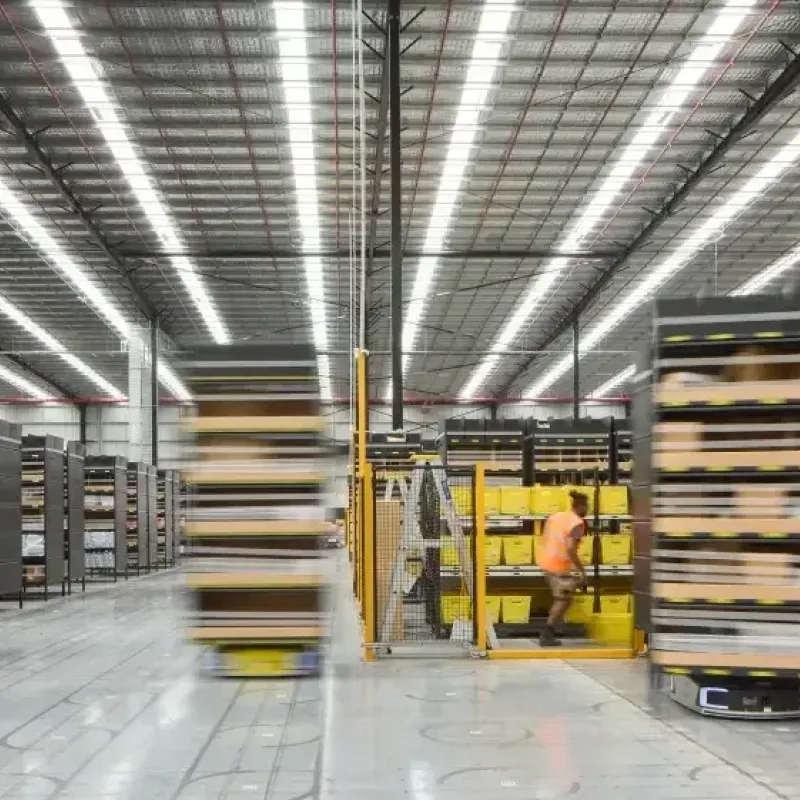 Automated warehouse with robotic shelving units moving along designated paths, optimizing storage and retrieval efficiency.